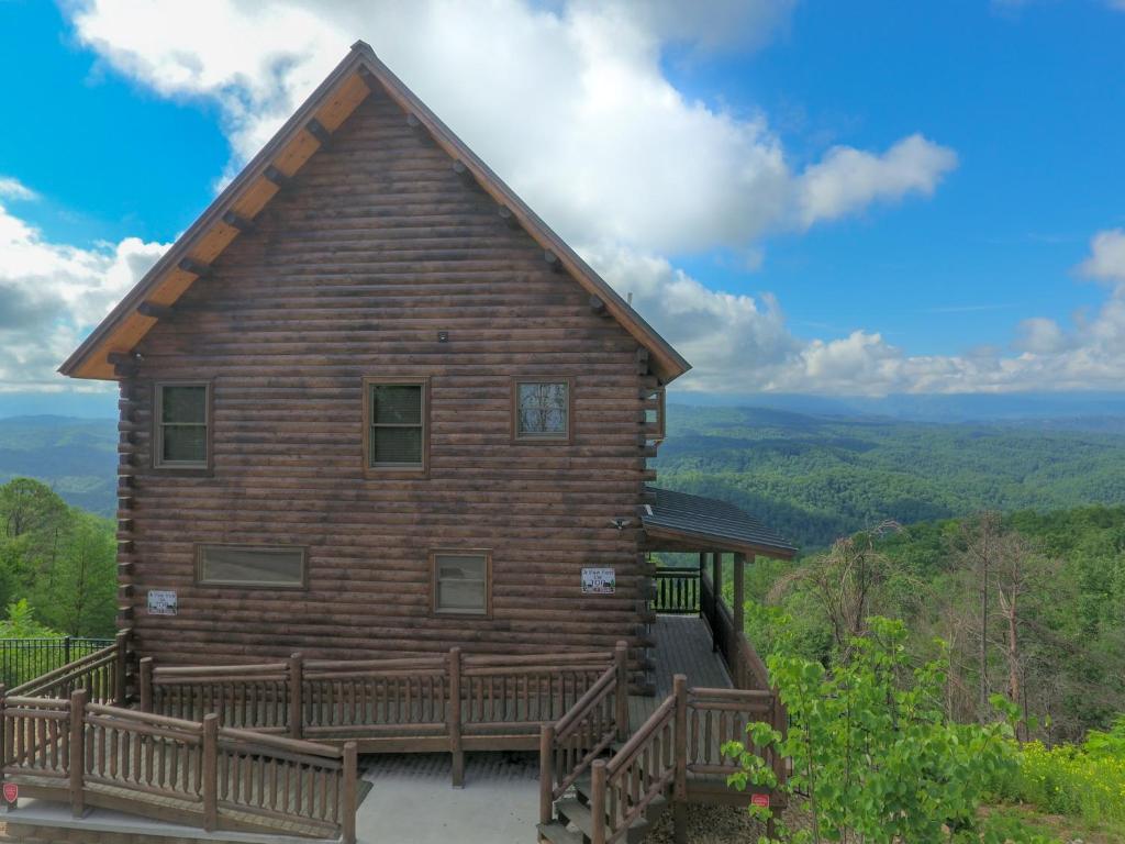 a log cabin with a deck and a view of the mountains at A View from the Top in Sevierville