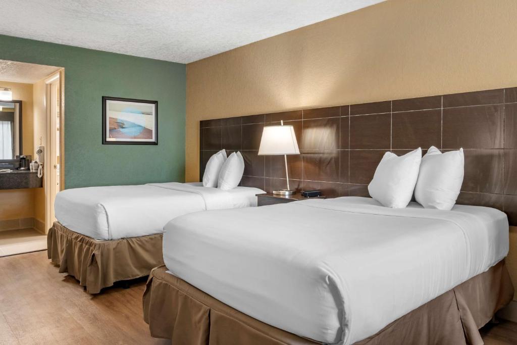 Rúm í herbergi á Best Western Space Shuttle Inn