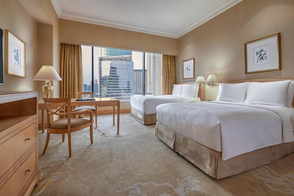 a hotel room with two beds and a desk at JW Marriott Hotel Jakarta in Jakarta