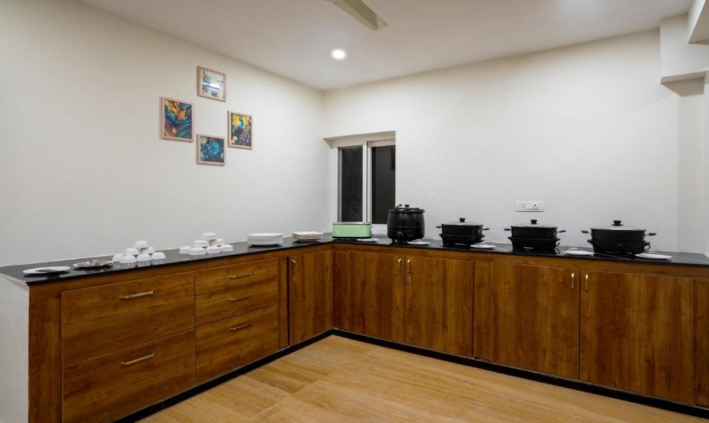 a kitchen with a counter top with pots and pans at Treebo SY Inn, Gachibowli DLF in Hyderabad