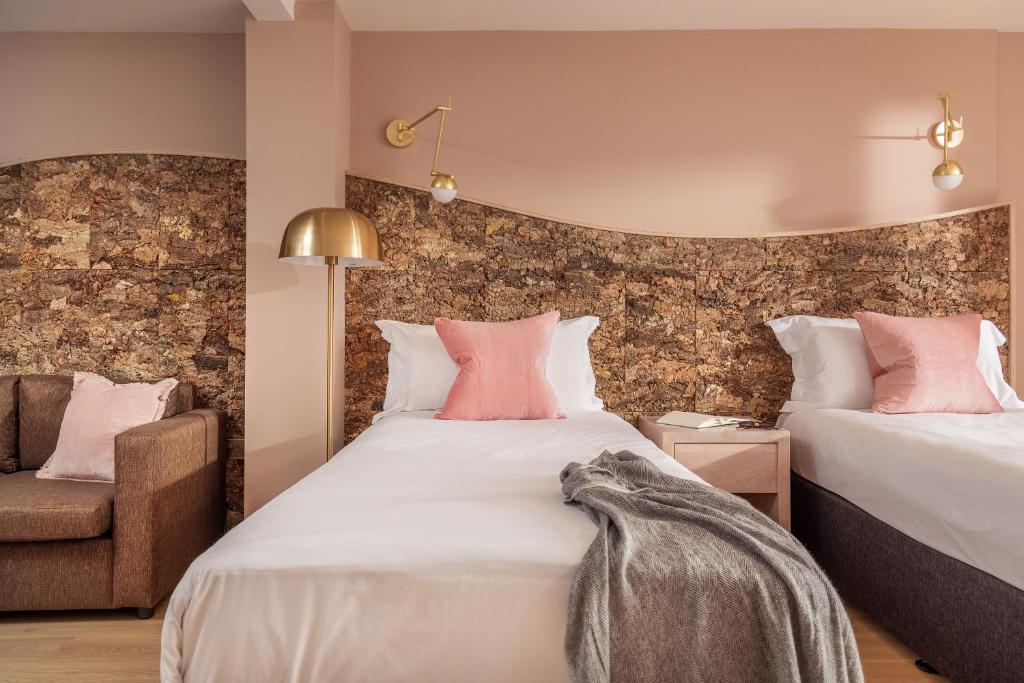 a bedroom with two beds and a chair at Bedruthan Hotel & Spa in Newquay
