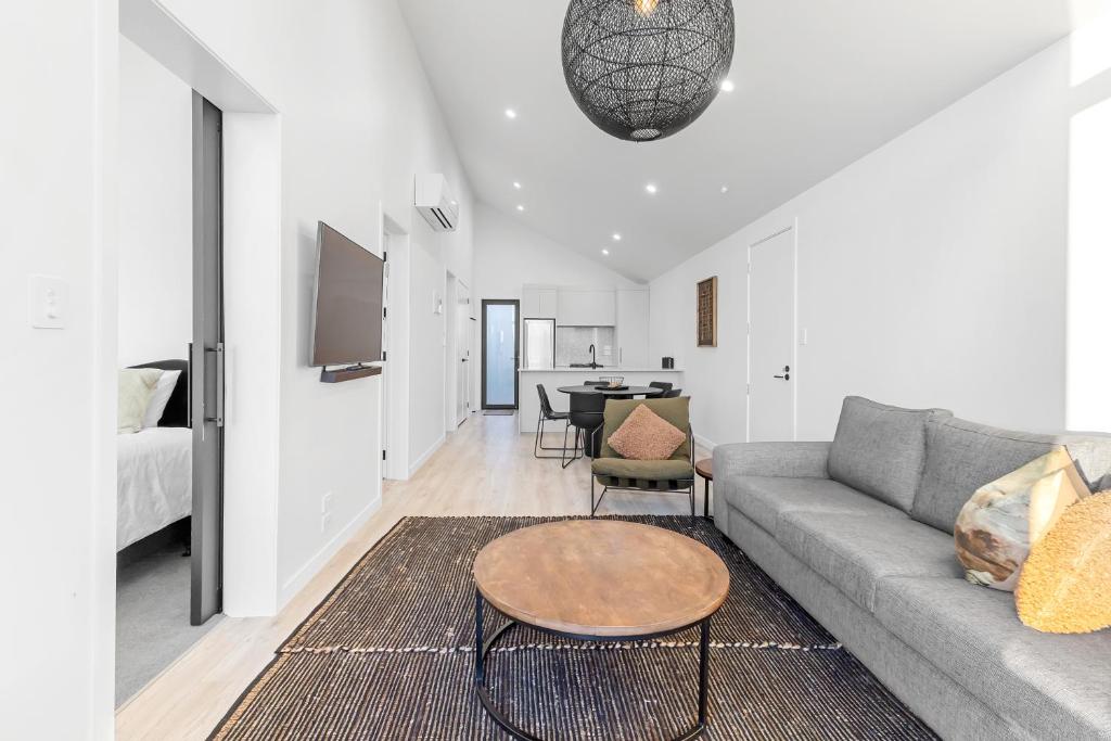a living room with a couch and a table at Absolute Lakefront House in Taupo