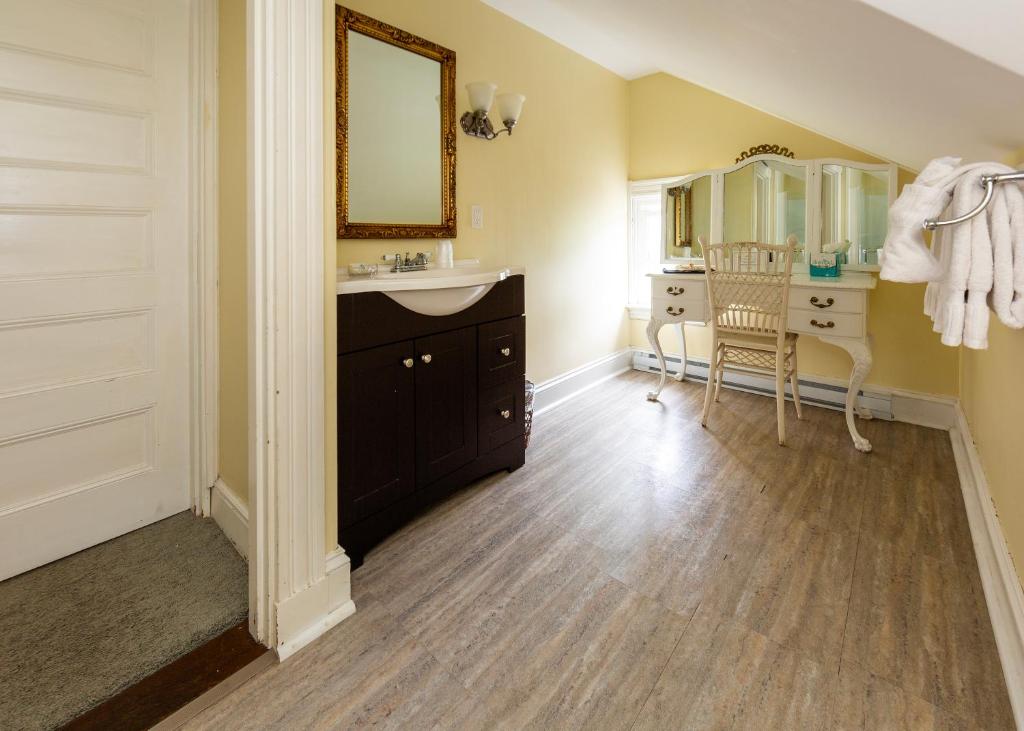 a bathroom with a sink and a vanity and a mirror at Thornhedge Inn in Bar Harbor