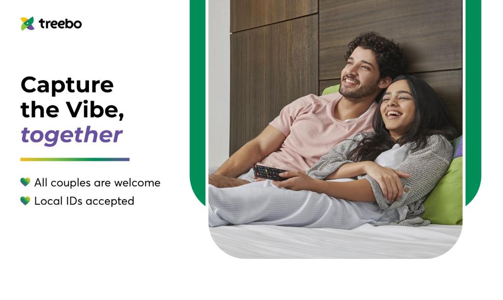 a man and a woman sitting on a bed at Treebo SY Inn, Gachibowli DLF in Hyderabad