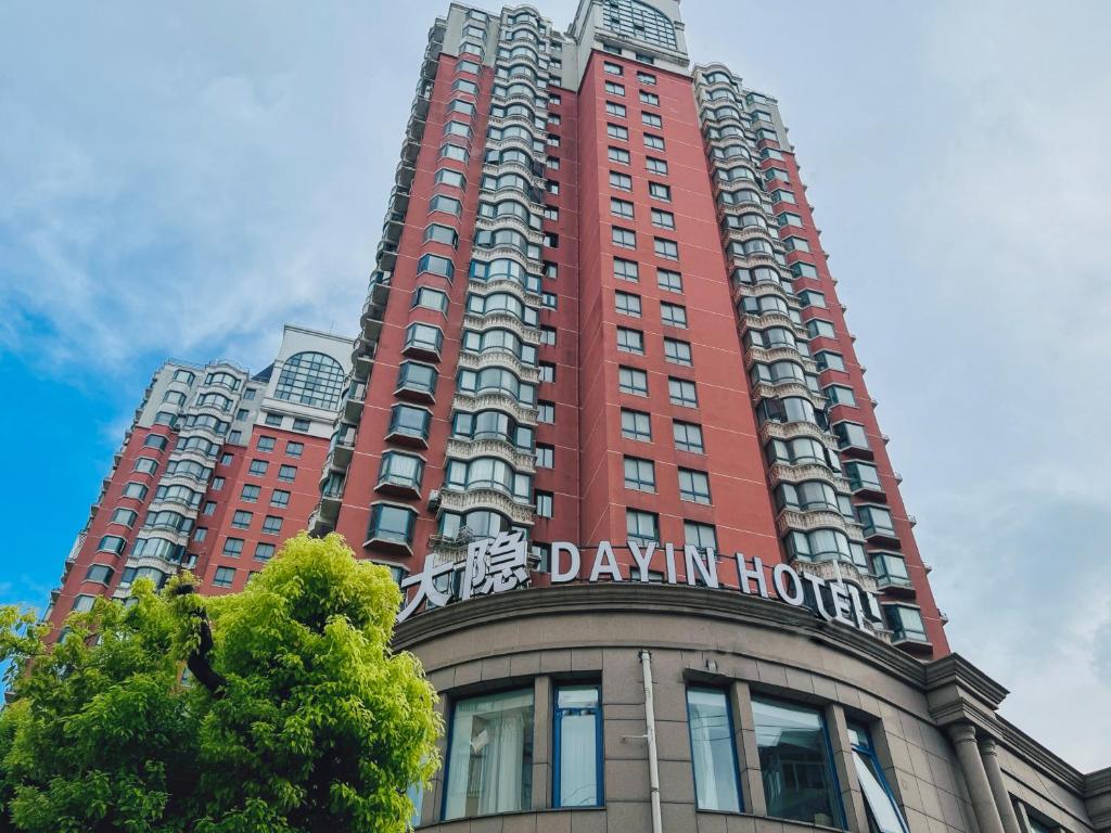 a tall red building with a sign on it at Dayin Garden Hotel -Near People's Square & Nanjing Road-Large Social Area -Bar -Café -Gym -Free Laundry Luggage Storage -24H Front Desk-English Service in Shanghai