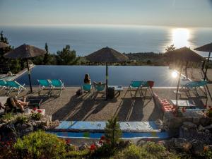a group of people sitting in chairs by a pool at Serenity Boutique Suites in Athani