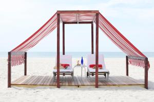 a gazebo with two chairs and a table on the beach at The Virginia and Cottages in Cape May +19 photos