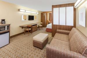 a hotel room with a bed and a living room at Microtel by Wyndham South Bend Notre Dame University in South Bend