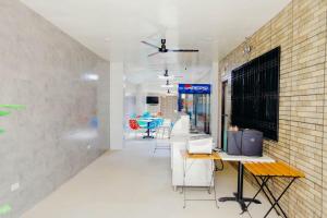 a room with tables and chairs and a brick wall at HalfWay House Hostel Mactan Cebu Airport in Mactan