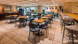 a restaurant with rows of tables and stools at Best Western Plus Regency Inn and Conference Centre in Abbotsford