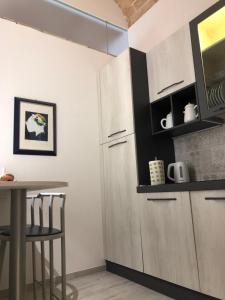 una cucina con mobili bianchi e tavolo di B & B Via Cavour a Termoli Altre 25 foto