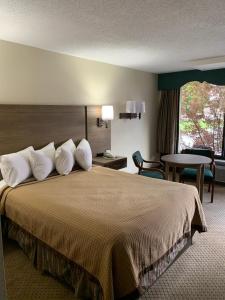 A bed or beds in a room at Riverside Motor Lodge - Pigeon Forge