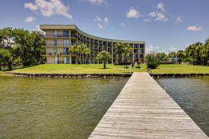 a building with a dock in front of a body of water at Pirates Bay III in Fort Walton Beach