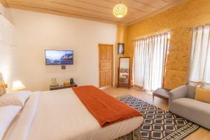 a bedroom with a large bed and a couch at Seclude Shimla, Taraview in Shimla