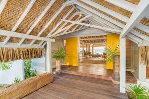 an open patio with a white pergola with palm trees at Moorea Island Beach Hotel in Moorea