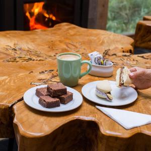 a table with a plate of brownies and a cup of coffee at Hostería Verde Morada in Villa La Angostura