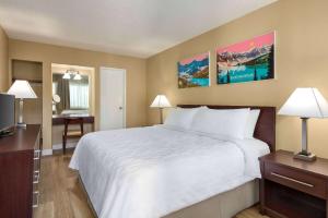 a hotel room with a large bed and a desk at Travelodge by Wyndham Presidio San Francisco in San Francisco +37 photos