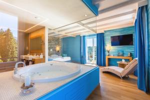 un ampio bagno con una grande vasca in una stanza di Kurhaus Cademario Hotel & SPA - Adults Only a Cademario