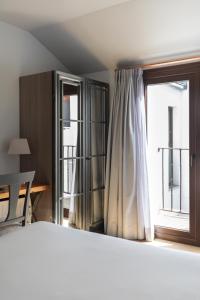 un dormitorio con una cama y una ventana en Hotel Boutique Posada de Sillería, en Toledo