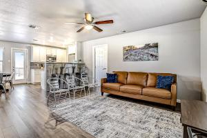 a living room with a couch and a kitchen at Pecan Row Getaway in New Braunfels