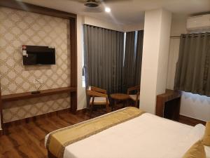 a hotel room with a bed and a television at Hotel Royal Palace in Guwahati
