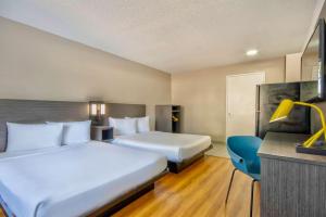 a hotel room with two beds and a tv at Studio 6-Austin, TX - Midtown in Austin