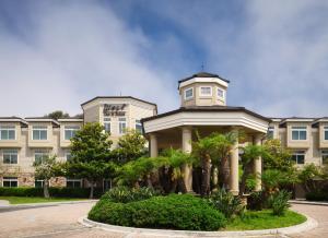 a building with a clock tower on top of it at West Inn & Suites in Carlsbad