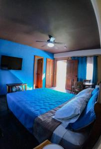 a bedroom with a bed with blue walls and a ceiling at Casa Morada in Antón