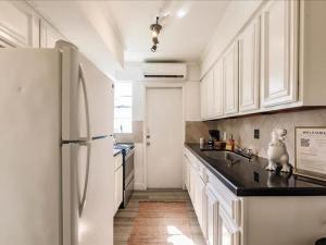 a kitchen with white cabinets and a white refrigerator at Deco Bungalow 1block from beach with parking in Miami Beach
