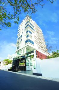 a tall white building in front of a street at Fair View Hotel Colombo in Colombo