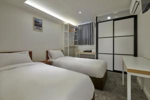a hotel room with two beds and a desk at Eight Rest Hostel Myeongdong in Seoul