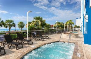 a hot tub with chairs and the ocean in the background at Bay View Resort Myrtle Beach in Myrtle Beach