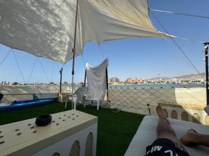 a person laying on a bed under an umbrella at קראוון בלגונה in Eilat