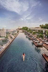 a person standing in the water at the infinity pool at a resort at Marina Bay Sands in Singapore