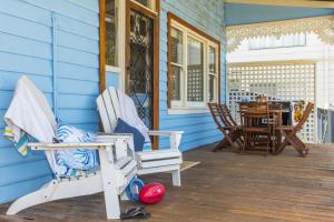 um alpendre com duas cadeiras de baloiço e uma mesa em Docs Cottage - Ocean Views em Lancelin