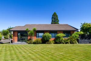 a house with a large lawn in front of it at Families and Groups, Chch Airport, Spa Pool in Christchurch