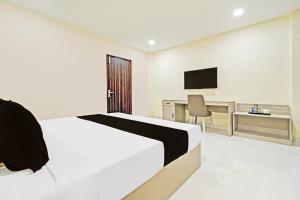 a bedroom with a bed and a desk and a television at Super Collection O Sanath Nagar Near Railway Station in Hyderabad