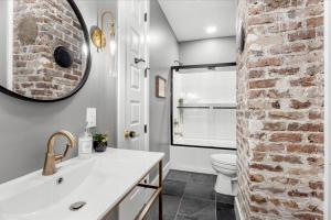 a bathroom with a white sink and a brick wall at Carter Jack Suite B Beach Fire Pit Downtown in Biloxi +29 photos