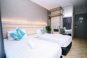 a hotel room with two beds and a mirror at Swing & Pillows - TAR UMT Setapak in Kuala Lumpur