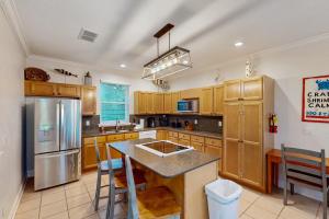 a kitchen with wooden cabinets and stainless steel appliances at Serenity Now in St. George Island