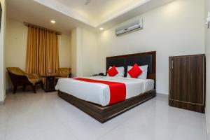 a bedroom with a large bed with red pillows at Hotel Tarrk Near IGI Airport in New Delhi