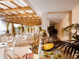 una sala da pranzo con tavolo e cibo di Taormina Panoramic Hotel a Taormina
