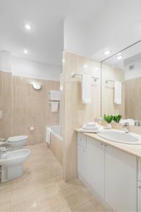a bathroom with a sink and a toilet and a mirror at Residence St. Andrew's Palace in Warsaw