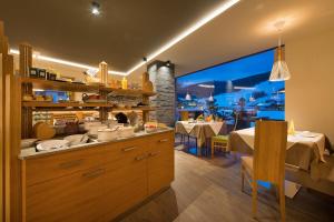 un ristorante con cucina e vista su un tavolo di Hotel Roberta Alpine Adults only a Livigno