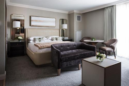 a hotel room with a bed and a couch at Delamar West Hartford in West Hartford