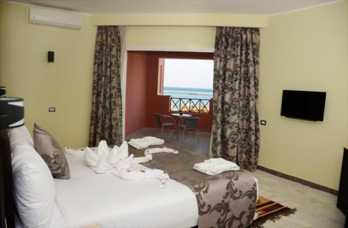 a hotel room with a bed with towels on it at Casa Mare Resort - ex, Royal Tulip Beach Resort in Port Ghalib