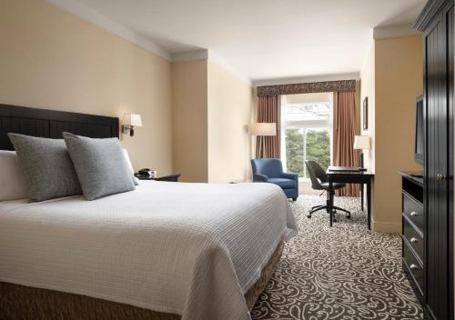 a hotel room with a bed and a desk at West Inn & Suites in Carlsbad