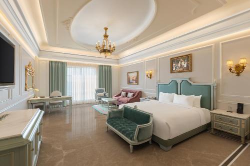 a bedroom with a bed and a living room at Hotel Hillock Ahmedabad in Ahmedabad