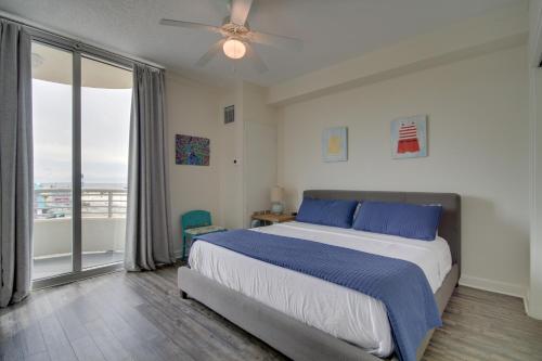 a bedroom with a bed with blue pillows and a window at Beachfront Biloxi Condo Balcony and Community Perks in Biloxi