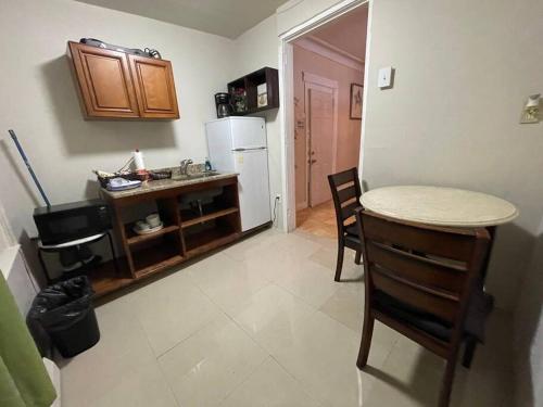 a kitchen with a table and a white refrigerator at *PRIVATE* Studio 5 minutes from LGA/ US Open in East Elmhurst